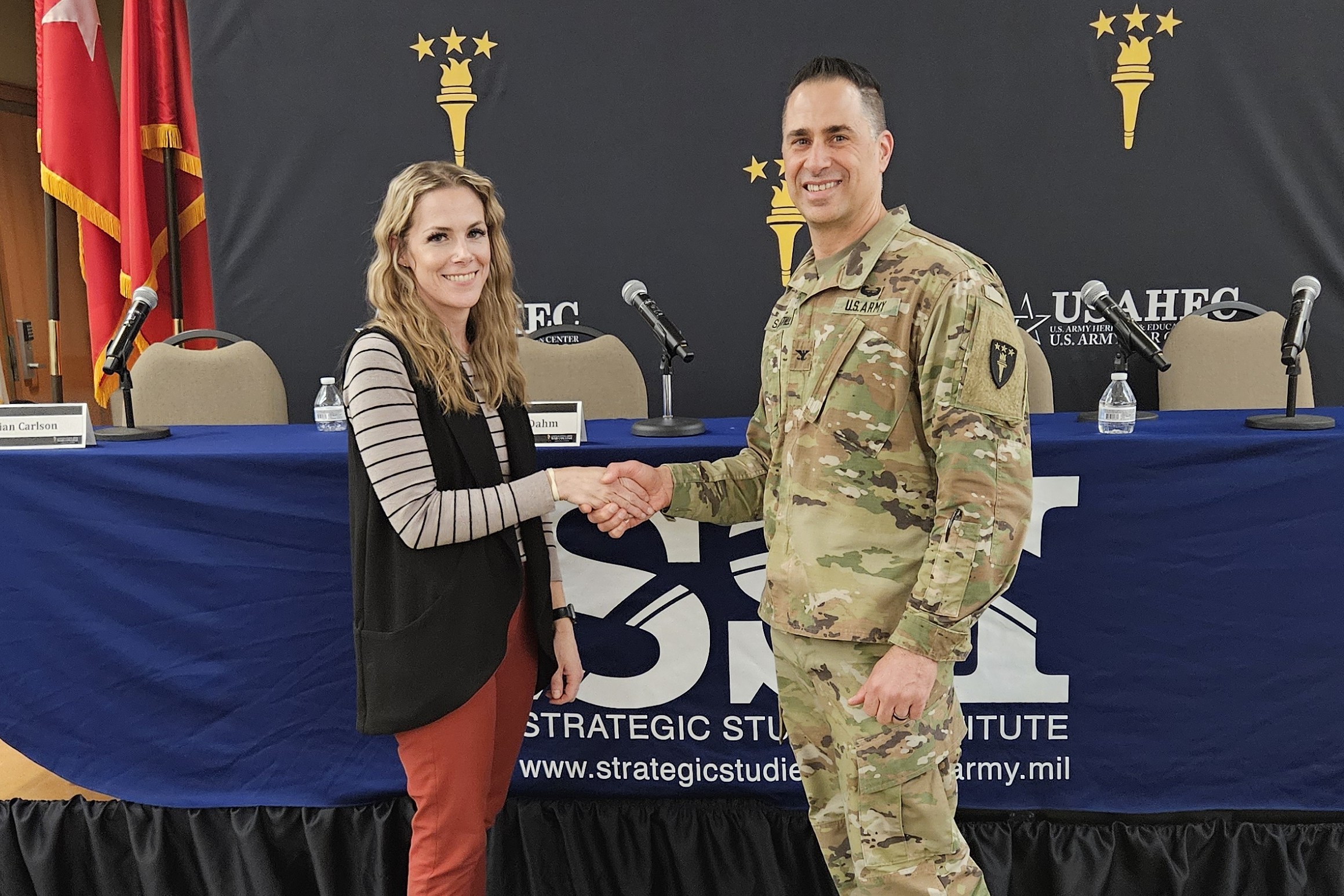Ms. Missi Holley, SSI’s administrative officer, receives a coin from USAWC Commandant Colonel Donald Santillo.